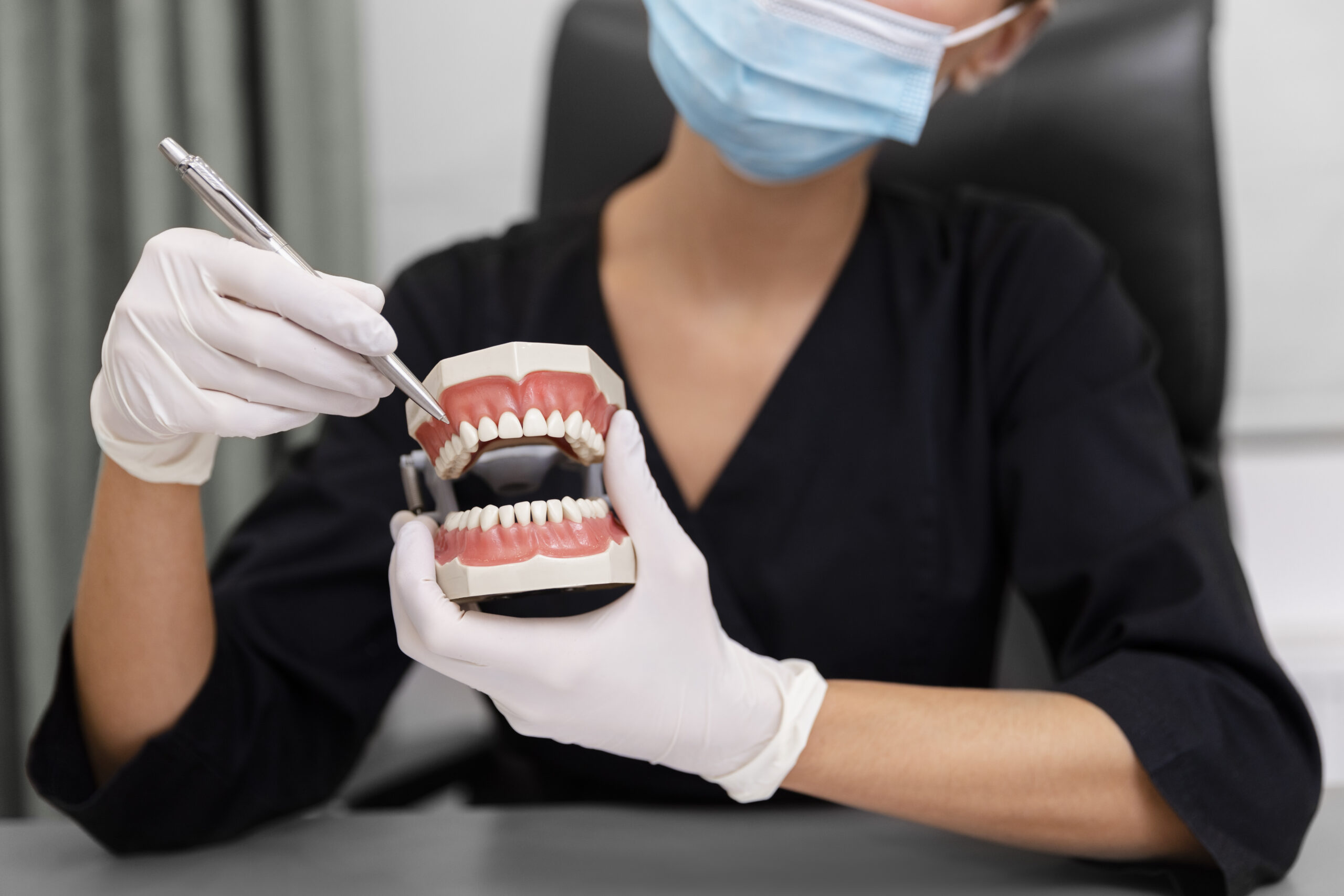 https://dentalreise.ch/wp-content/uploads/2022/10/close-up-dentist-holding-teeth-model-scaled.jpg