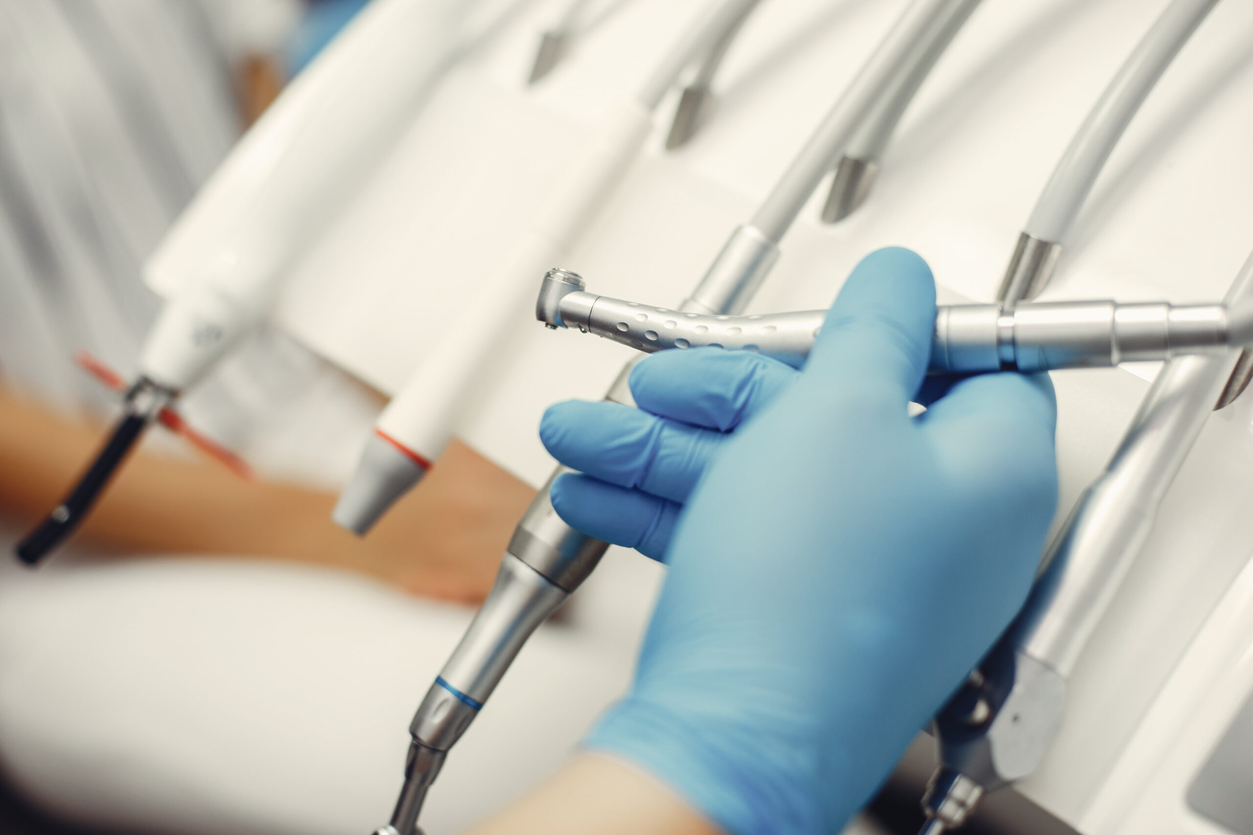 Metal instruments for the treatment of teeth. Dental clinic. Hands in a blue gloves